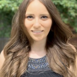 Portrait of Ashley Trujillo-White, verdant background.