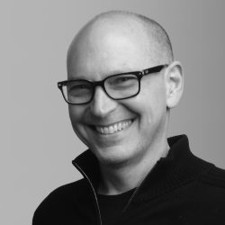 Portrait of Chris Hyams, CEO of Indeed shown in greyscale.