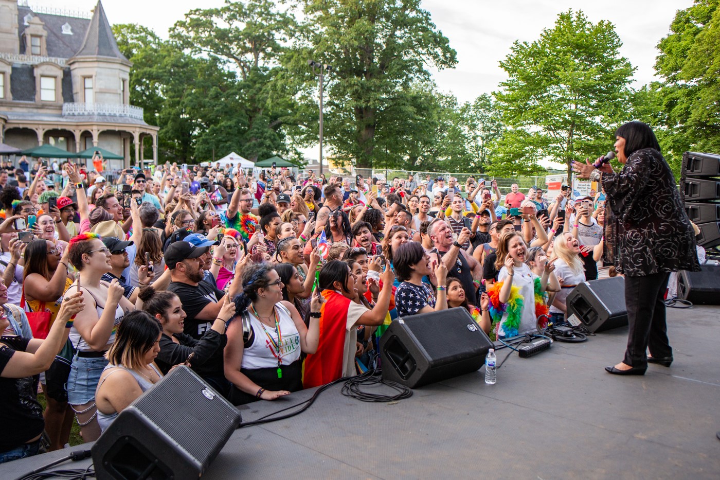 Audience gathered enthusiastically watching an outside concert.